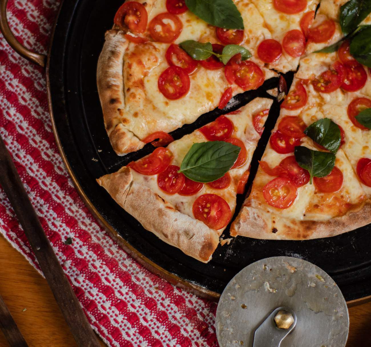 Pizza artesanal Capannone com tomates e manjericão